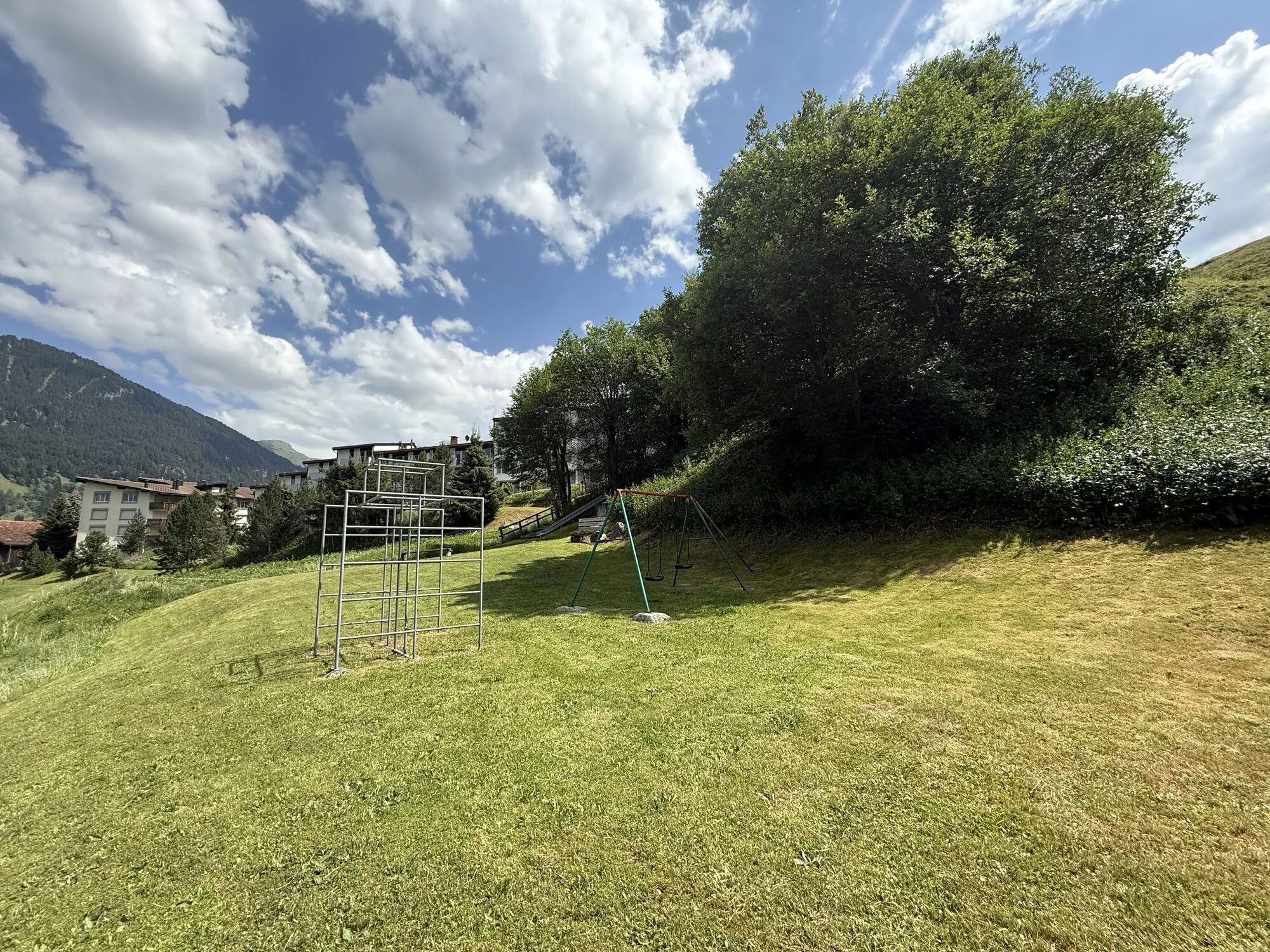Parque infantil con estructura de trepa y columpio